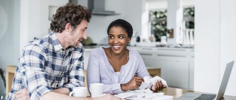 Pareja que analiza recibos sobre la mesa de la cocina