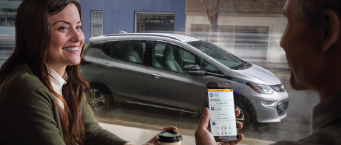 couple discussing new car technology in a coffee shop with cell phone